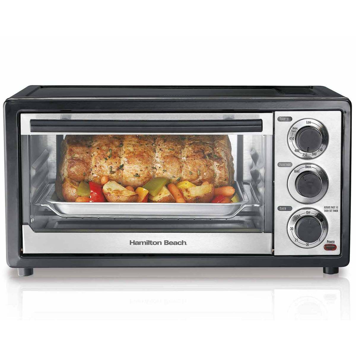 Hamilton Beach model 31508, dark single-cavity toaster oven with silver-looking control fascia, glass door and three manual dials; staged roast is illustrative.
