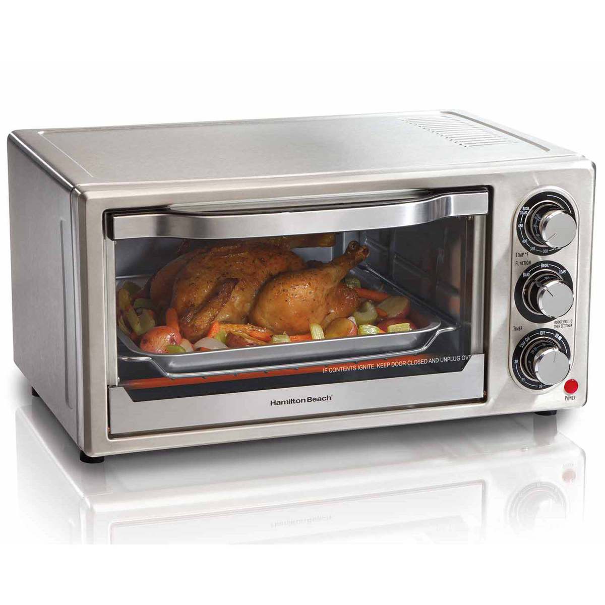 Hamilton Beach exact model 31511, stainless-steel exterior single-cavity toaster oven with glass door and three manual dials; staged chicken and vegetables are illustrative.